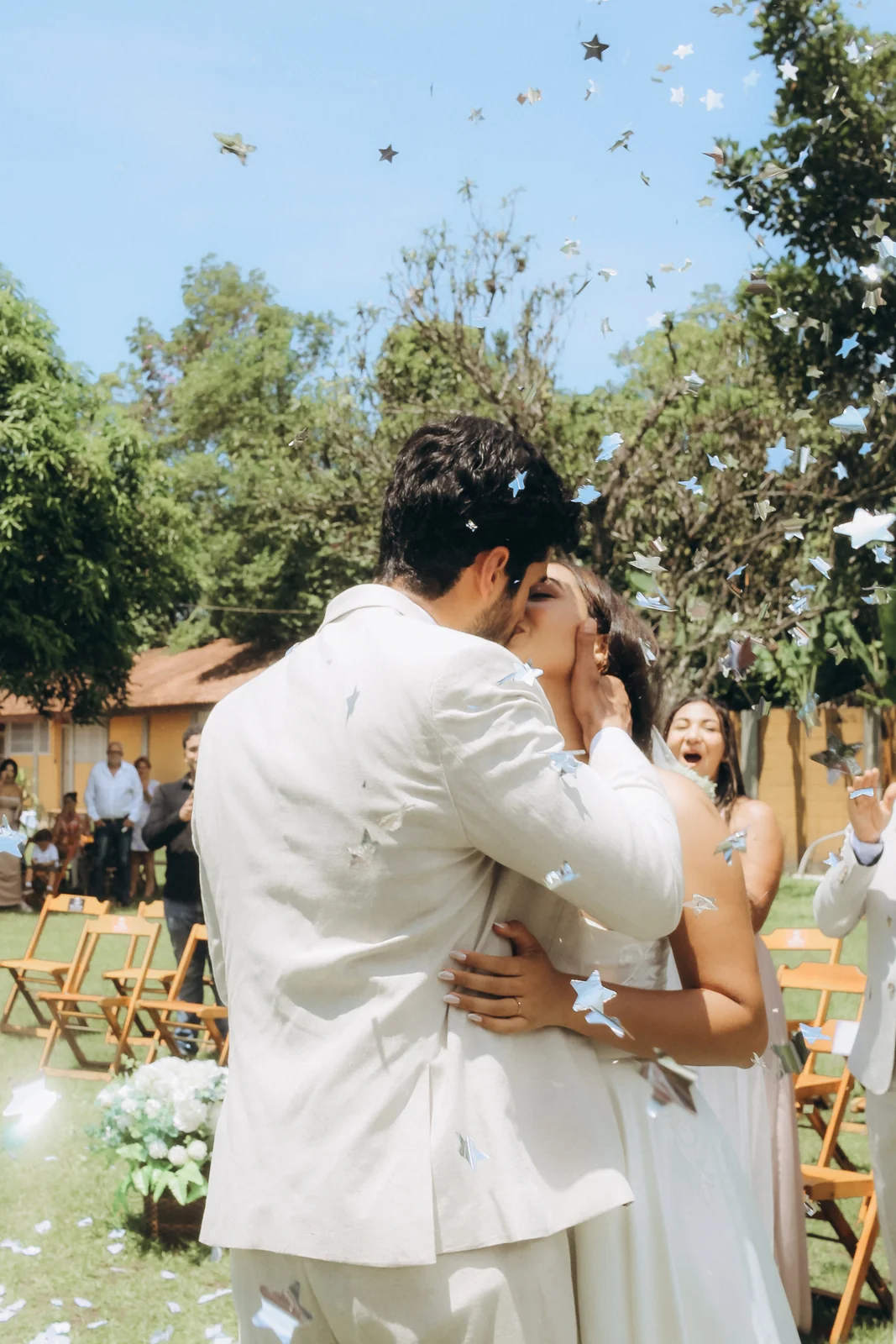 Casal se abraça durante uma chuva de pétalas